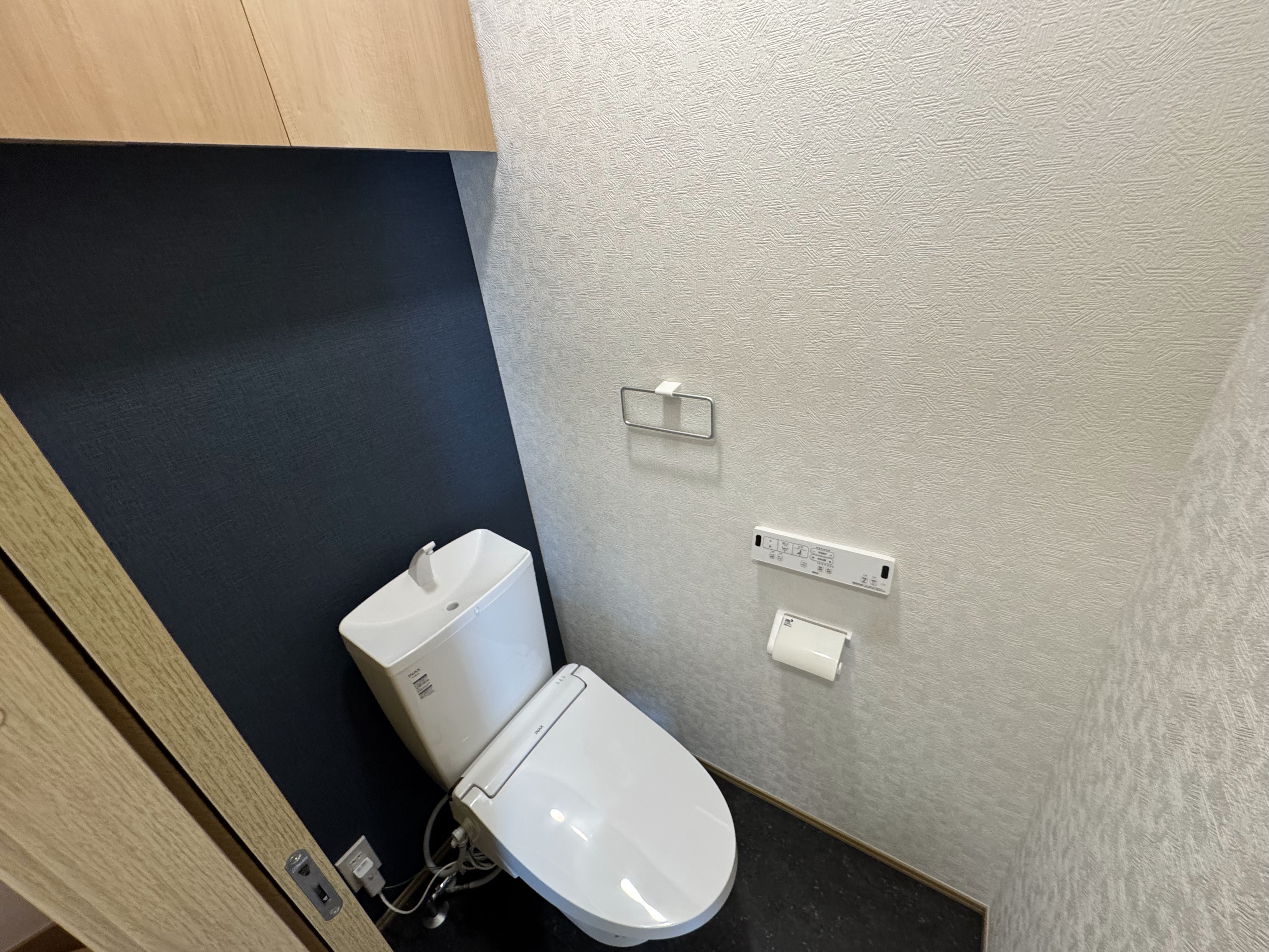 上部に収納棚のあるシャワートイレ付きのトイレスペース