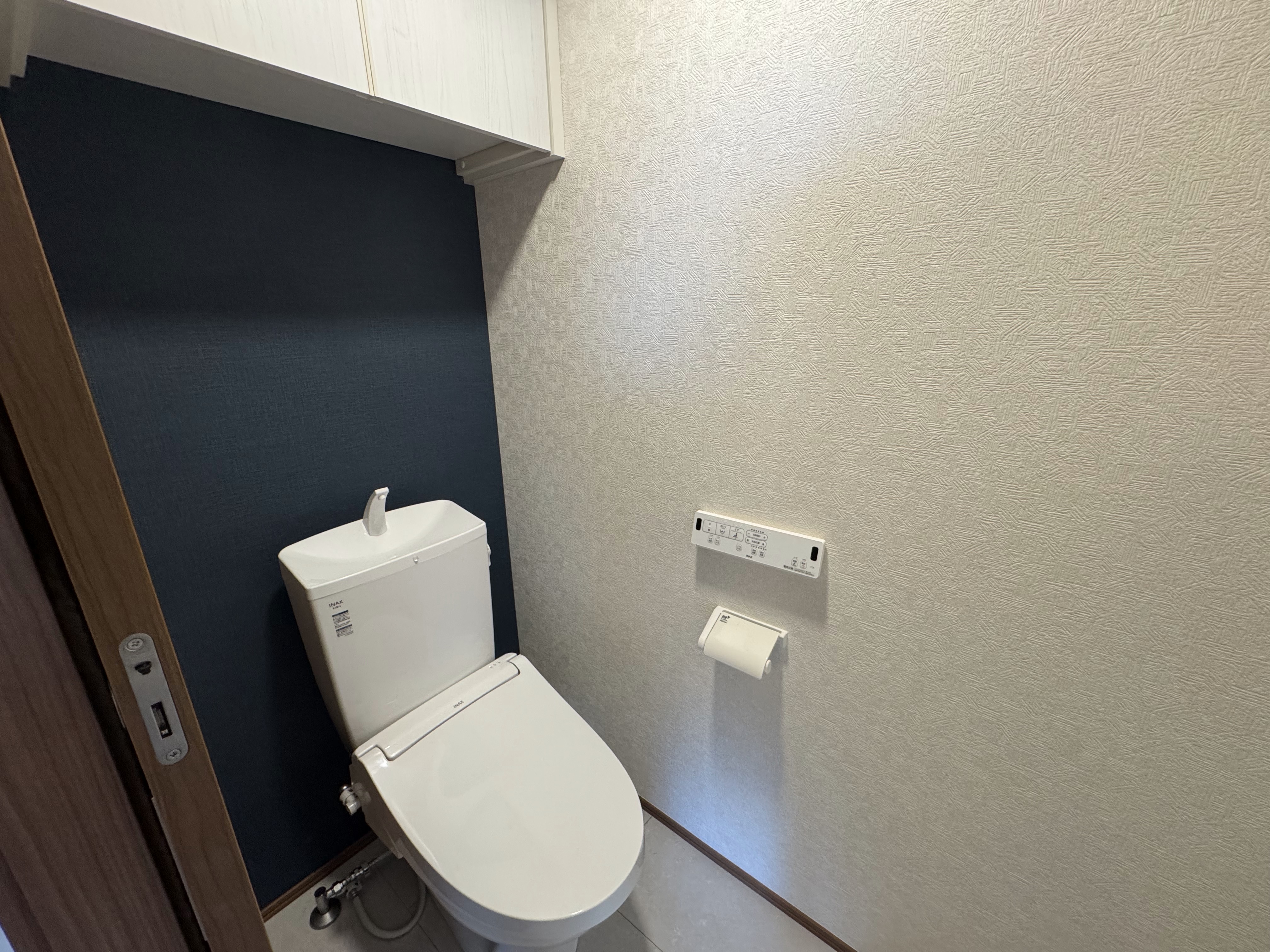 上部に収納棚のあるシャワートイレ付きのトイレスペース